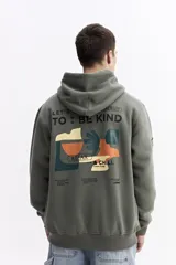 Canguro con capucha color verde oliva, de corte regular, con estampado gráfico multicolor en la espalda que incluye texto y formas abstractas.