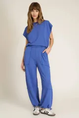 Pantalón de jogging azul de tejido de rizo suave con cintura alta elastizada, bolsillos laterales, costuras expuestas y lazo en el tobillo.