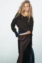 Falda midi negra de tejido satinado, corte recto y tiro alto con cintura elástica.