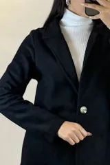 Saco largo de gamuza en color beige, con diseño de solapas clásicas, cierre frontal y corte recto.
