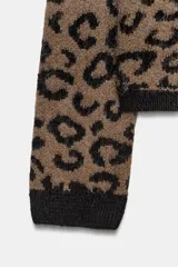Chaqueta abierta de punto con cuello redondo y manga larga. Presenta un diseño de jacquard con estampado animal y detalles de ribetes en color negro en cuello, puños y borde frontal.