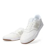 Championes urbanos New Balance de cuero sintético color blanco con detalles en verde claro y suela de goma color caramelo.