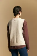 Chaleco tejido de punto en color azul marino, con diseño de textura sutil en relieve, escote redondo y terminaciones acanaladas en cuello, sisas y ruedo.