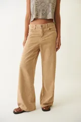 Pantalón jean color arena, de corte ancho y tiro bajo, con efecto desgastado.