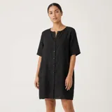Camisa holgada blanca de manga corta y largo medio, confeccionada en mezcla de algodón, con cierre frontal de botones.