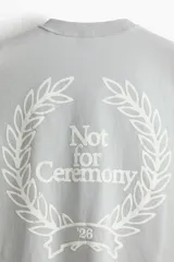 Remera de algodón en punto pesado, color verde menta, con cuello redondo acanalado, hombros caídos y diseño estampado en el pecho con la frase 'Not for Ceremony'.
