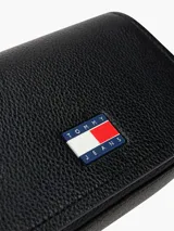 Cartera bandolera negra de poliuretano con correa ajustable, cierre con solapa y logo engomado de Tommy Jeans.