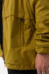 Campera de nylon color mostaza, estilo 'gorpcore', con forro de jersey de algodón y corte confortable. Presenta cierre frontal, capucha y bolsillos laterales. Estampado en el pecho con el logo de la marca y la frase "Release the hounds".