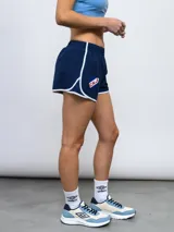 Short de entrenamiento Umbro color celeste con ribetes en azul marino y logo de la marca estampado en el frente. Presenta cintura elástica y paneles laterales de malla.