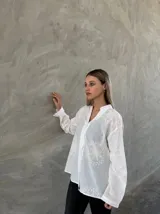 Camisa blanca de mangas largas con bordados florales.