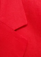 Chaqueta de corte recto con cuello de solapa, cierre frontal de doble botonadura y bolsillos laterales de ribete. Presenta mangas largas con puños abotonados.