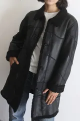 Campera de napalán de cuero genuino con interior de piel sintética, diseño con capucha desmontable, cierre frontal con botones y bolsillos laterales.