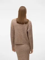 Sweater de punto grueso color beige melange, con cuello redondo y puños acanalados. Presenta un tejido acanalado vertical.