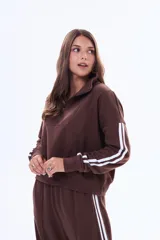 Buzo de felpa color marrón con medio cierre frontal, cuello alto y mangas largas con dos franjas blancas laterales.