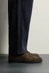 Zapato de cordones tipo derby para hombre, fabricado en piel con acabado en serraje de color azul marino, con horma redonda y suela a contraste.