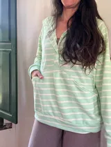 Canguro verde agua a rayas horizontales blancas, de corte amplio, con escote con broches para facilitar la lactancia, bolsillo al frente y puños en mangas y bajo.