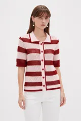 Top de punto calado con rayas horizontales en color rosado y rojo, de manga corta, con cuello tipo polo y cierre frontal con botones.