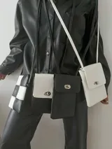 Monedero pequeño con correa larga, con diseño de tablero de ajedrez en blanco y negro.