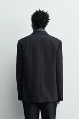 Blazer de corte regular fit confeccionada en tejido de lana italiana. Presenta cuello con solapas de pico, cierre frontal de botonadura cruzada, bolsillo de vivo en el pecho y bolsillos con solapa en la cadera.