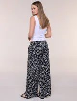 Pantalón de poliéster de corte ancho tipo palazzo y calce relajado, con estampado de hojas en tonos azules, cintura alta elastizada con cordón ajustable y bolsillos laterales.