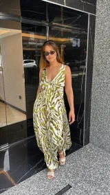 Vestido largo estampado con escote en V profundo y tirantes anchos. El diseño presenta un frunce o nudo en el centro del busto y tajos laterales en la falda.