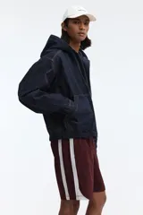 Short deportivo de nylon color bordó, con franjas laterales blancas, cintura elástica con cordón de ajuste blanco y bolsillos laterales.