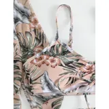 Conjunto de traje de baño de tres piezas con estampado de hojas tropicales en tonos blanco y negro. Incluye un top tipo tankini con cordón ajustable en el centro, un short de tiro alto y una camisa abierta de manga larga tipo salida de baño.