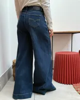Jean de tiro alto con corte wide leg, confeccionado en denim azul oscuro con costuras en contraste.