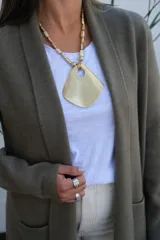 Collar de diseño artesanal con cadena compuesta por cuentas metálicas texturadas y dije central grande de forma irregular con acabado mate.