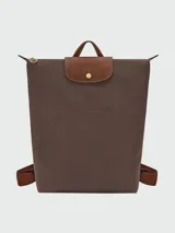 Mochila Longchamp de la línea Le Pliage Original, tamaño M, en color rosado con solapa y asas de cuero marrón.