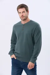 Remera de algodón texturada color verde oscuro, con cuello Henley de tres botones y manga larga.