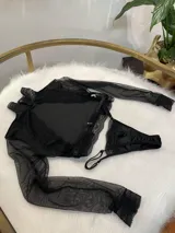 Conjunto de lencería compuesto por un top de cuello alto con mangas largas de microtul y detalles de encaje, y una tanga regulable de terciopelo y encaje.