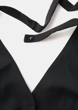 Chaleco negro con cuello en V, cierre frontal con botones y diseño slim.
