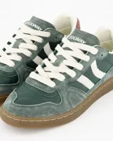 Championes Coolway modelo Goal Green Pulse, confeccionados en gamuza y cuero premium, de diseño retro-sport en tonos verde, tostado, blanco y detalles en rosado. Cuenta con cordones blancos, paneles laterales en contraste y suela flexible de goma.