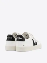 Championes urbanos Veja modelo Recife, color blanco con detalles en negro. Diseño de caña baja con cierre de tres tiras de velcro, confeccionados en cuero ChromeFree con suela de caucho.