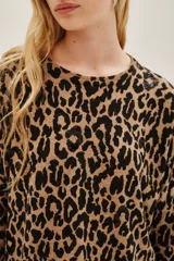 Sweater de punto con estampado de leopardo en tonos marrón y negro, de manga larga y cuello redondo. Presenta detalles de lentejuelas negras aplicadas sobre el tejido. Confeccionado en una mezcla de poliamida, acrílico, cachemira y seda.