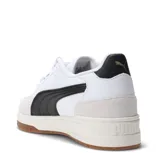 Championes Puma modelo Shuffle Downtown, de diseño retro urbano. Presentan una base blanca con detalles en negro, incluyendo la franja lateral característica de la marca, y refuerzos de gamuza en la puntera y el talón. Cuentan con suela de goma color caramelo y plantilla SoftFoam+ para mayor confort.