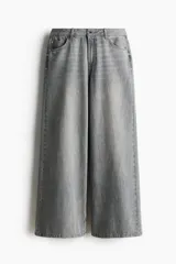 Jean de corte wide leg y tiro medio en denim color gris deslavado, con diseño de cinco bolsillos y cierre frontal con botón y cremallera.