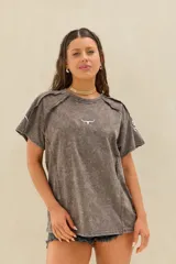 Remera marrón con efecto acid wash, corte oversize, mangas cortas caídas, costuras decorativas expuestas y pequeño logo bordado en el pecho.