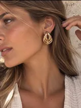 Aros dorados con diseño entrelazado de múltiples aros en forma de lágrima.