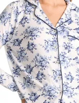 Conjunto de pijama de dos piezas con estampado animal print. La parte superior es una camisa de manga larga con cuello solapa, escote en V, cierre frontal con botones y bolsillo aplicado. El pantalón cuenta con cintura elástica y lazo de ajuste.