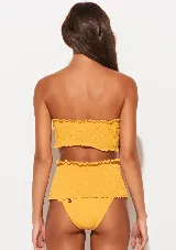 Conjunto de bikini amarillo con corpiño bandeau con volados y bombacha de tiro alto con volados.