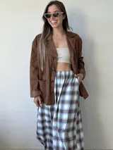 Pantalón de corte amplio tipo babucha, confeccionado en franela liviana con estampado de tartán escocés en tonos azules, blancos y marrones. Presenta una cintura elástica cómoda y adaptable.