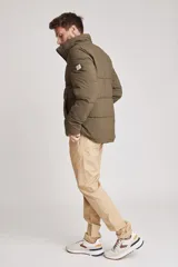 Cazadora acolchada tipo puffer color verde militar, con capucha desmontable, cierre frontal y bolsillos laterales con cierre.