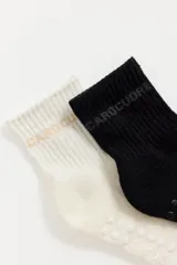 Pack de dos pares de medias cortas marca Caro Cuore, una en color blanco y otra en color negro. Presentan diseño acanalado en la caña con el nombre de la marca y suela antideslizante con puntos de silicona.