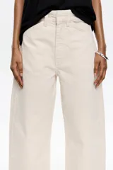 Pantalón vaquero de algodón orgánico color blanco crudo, tiro medio, corte barrel ancho y largo tobillero. Presenta bolsillos redondeados delanteros y bolsillos plastrón traseros.