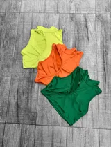 Top corto sin mangas, con cuello alto y abertura en el pecho.