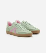 Championes de estilo retro tipo chutera, confeccionados en poliuretano color marrón con detalles en beige en los laterales y el talón. Presentan suela plana de goma color caramelo y cierre mediante cordones.