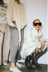 Bermuda de denim color blanco roto, tiro medio, con cinco bolsillos y bajo desflecado.