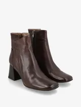 Botín de cuero negro con punta fina y cierre lateral. El tacón es ancho y de madera.